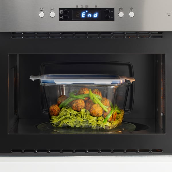 Microwave-safe glass container with lid heats meal, snap-lock lid.