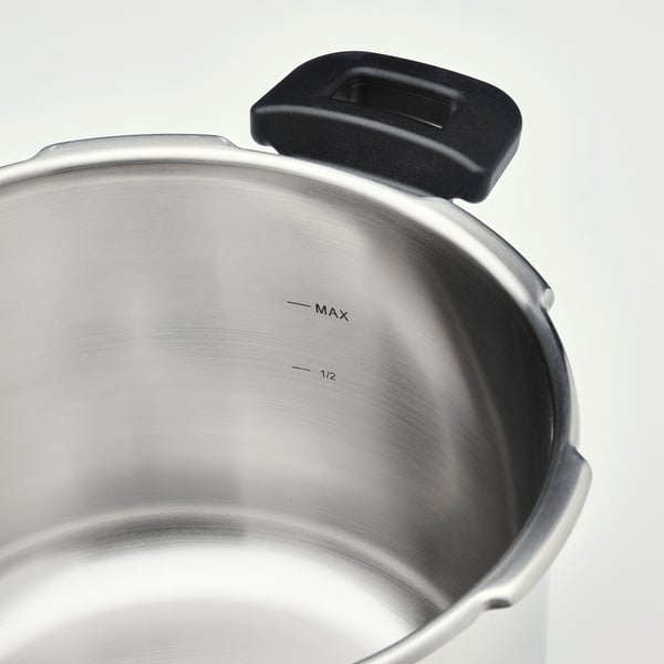 Shiny, stainless steel pressure cooker with black handle and max fill line.