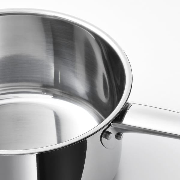 Modern, polished stainless-steel saucepan, reflecting light, with two rivets securing its sturdy handle.