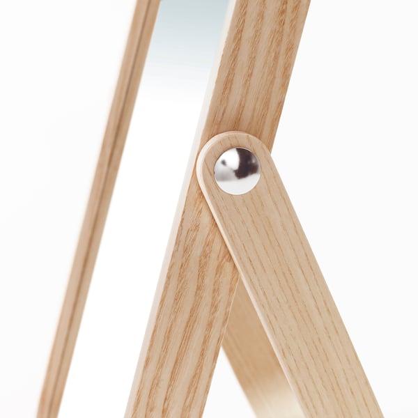 Close-up of oak-framed mirror joint, showcasing polished hinge for sturdy design.