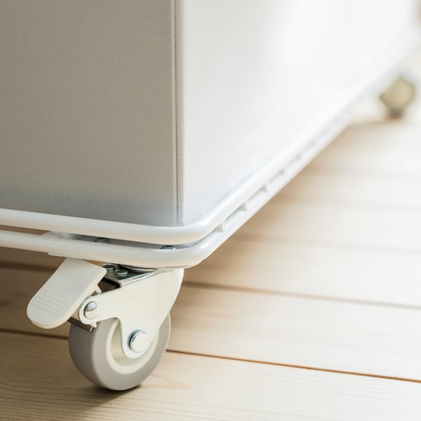 A close-up of a wheeled storage trolley. One castor is locked, ensuring stability.