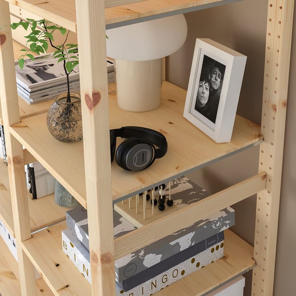 Wooden shelf displaying items: plant, lamp, photo, headphones, and boxes.