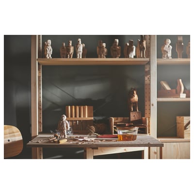 Woodworking studio with various wooden figurines and tools on a table and shelves.