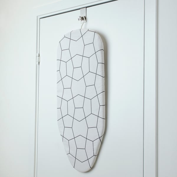 Door-mounted ironing board with geometric cover, folds flat for space-saving storage.
