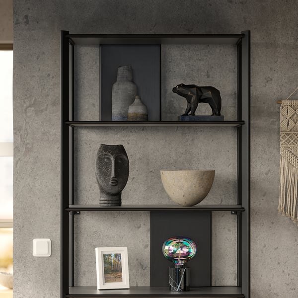 Modern black metal shelf with bamboo shelves, displaying artwork, vases, and a bear sculpture against a concrete wall.