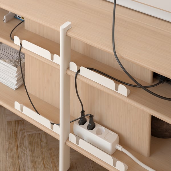 JÄTTESTA wooden shelf unit with white cable holder, organising cords neatly.