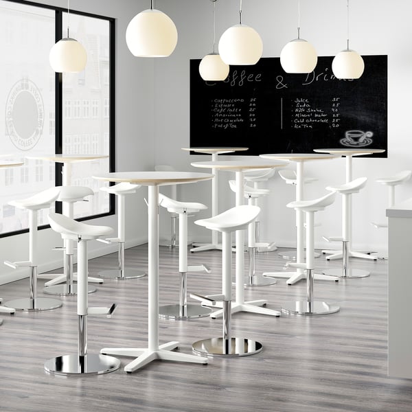 Modern café with white bar stools featuring adjustable heights, suitable for restaurant use, and hanging spherical lamps.