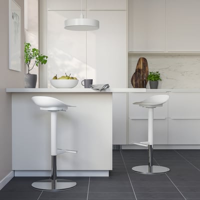 Two JANINGE bar stools under kitchen island with fruit, mug, and plants.