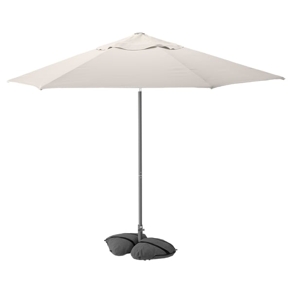 JOGGESÖ cream outdoor umbrella with tilt, aluminum pole, grey sandbags.