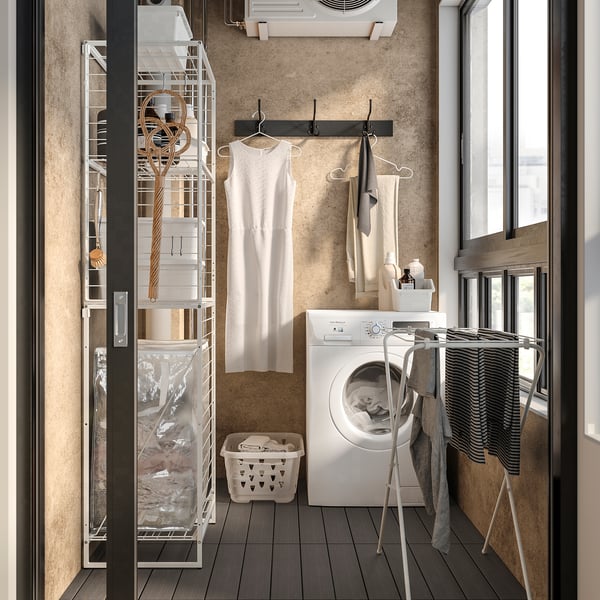 Small laundry room with JOSTEIN storage, clothes, supplies, and washing machine.