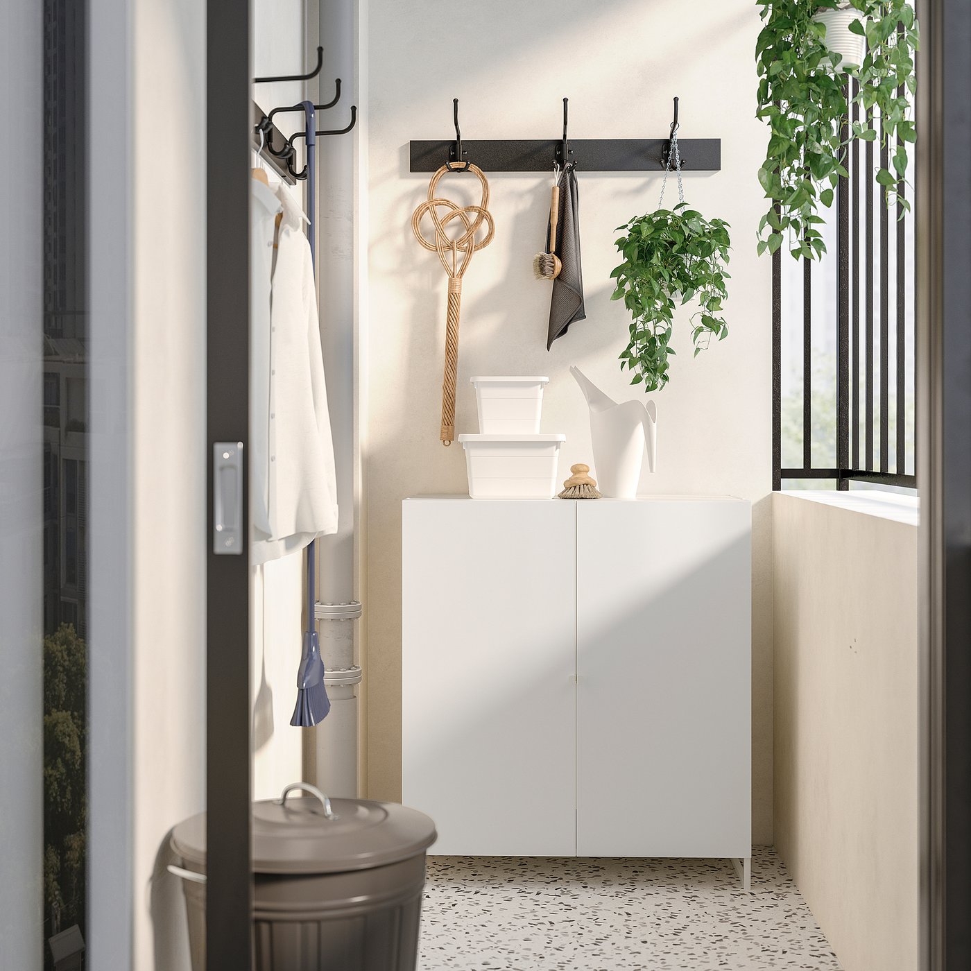 Small white cabinet with hooks, baskets, and plants. Laundry/bathroom storage. Moisture-resistant steel.