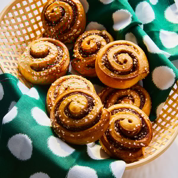Basket of golden cinnamon rolls topped with sugar.