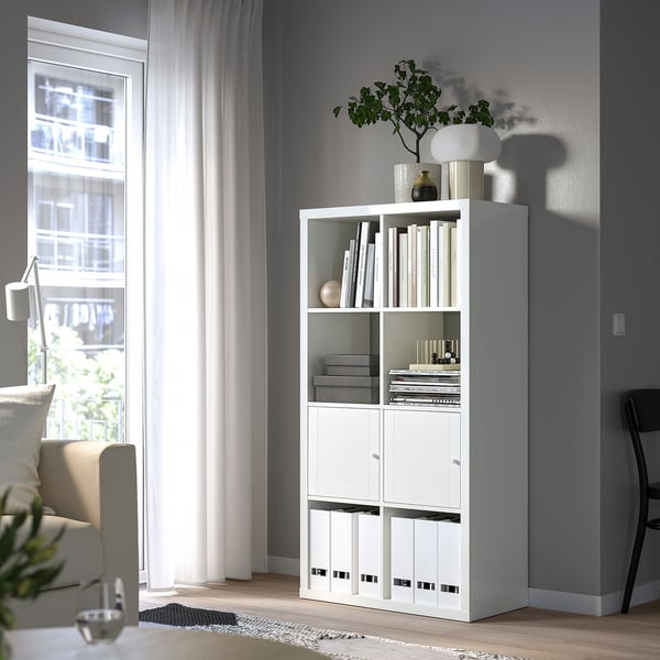 KALLAX shelf with books, vases, plant, near window & chair