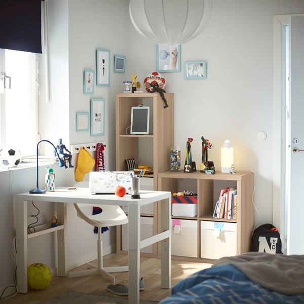 A organised kids room with white KALLAX shelves, a desk, and decorated walls.