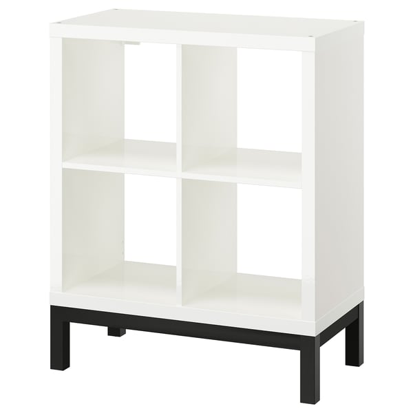 A white KALLAX shelving unit with a black underframe. It has an open, airy design with multiple compartments.