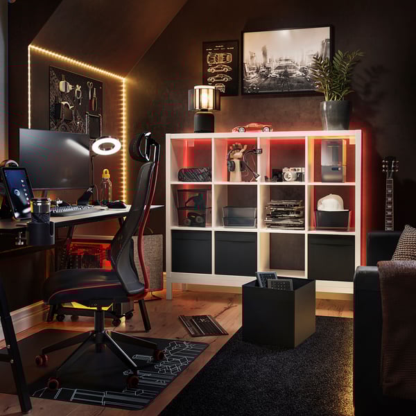 Modern home office: KALLAX shelf, office chair, desk with computer, guitar, couch.