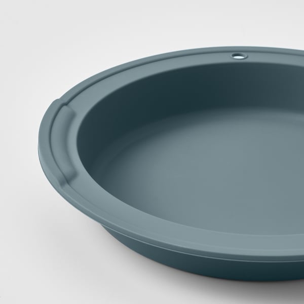 Close-up of a round, blue silicone baking dish; smooth, even surface and sturdy edges.