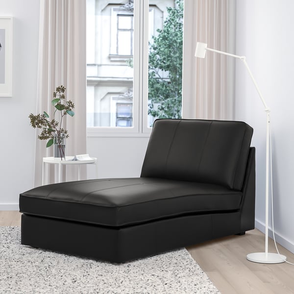 Black KIVIK leather chaise in modern living room by large window.