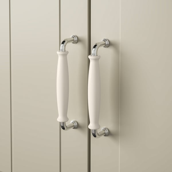 Chrome cabinet handles with white grips on light wood door.