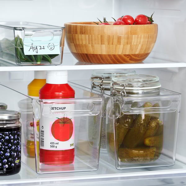 Clear fridge storage boxes hold ketchup, pickles, and tomatoes; stackable, with lids for freshness.