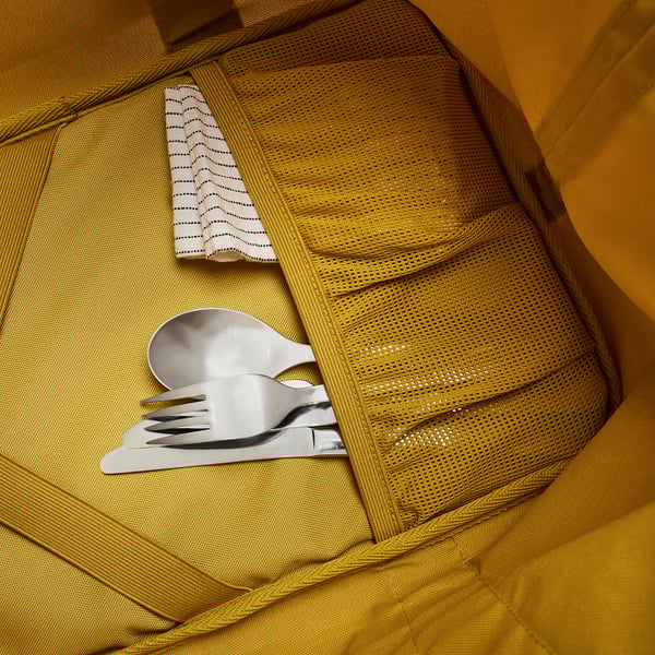 Open yellow cooler bag with mesh pocket. Contains silver utensils and white cloth. High-quality, insulated design for outdoor use.