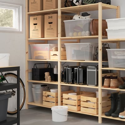 Wooden storage unit with shelves holding various items, including labelled boxes, sports gear, and tools.
