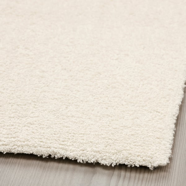 Close-up of a plush, white rug with a soft, thick pile. The texture appears luxurious and cosy, ideal for comfort and warmth.