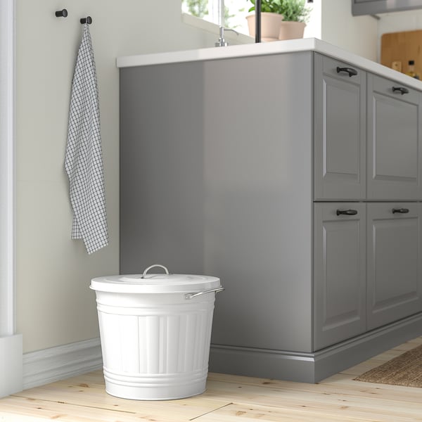 Small white KNODD bin fits under grey cabinet, wooden floor.