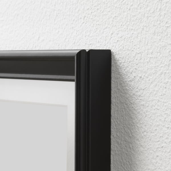 Black rectangular picture frame with a thin profile and smooth edge, mounted on a white wall.