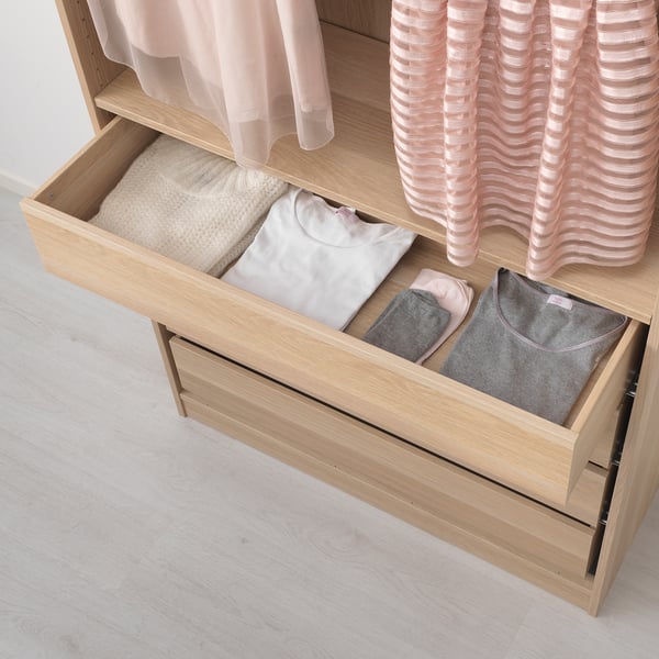 Open pax wardrobe drawer with neatly folded clothes. Integration with KOMPLEMENT boxes for organised storage.