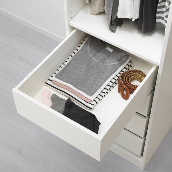 Open drawer with folded clothes, belt, and KOMPLEMENT box for small items.