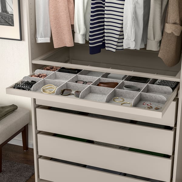 Open closet organiser drawer with felt compartments holding jewellery and accessories.