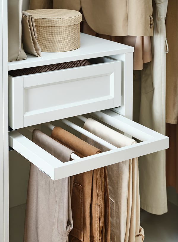 White KOMPLEMENT trouser hanger, holds rolled pants, integrated into closet, sleek design.
