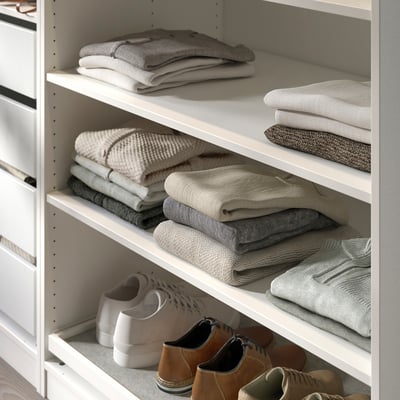 White KOMPLEMENT wardrobe shelf with neatly folded grey sweaters and boots.