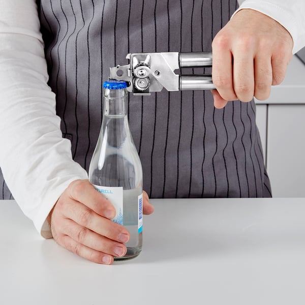 Person opens a bottle using a multi-functional opener.