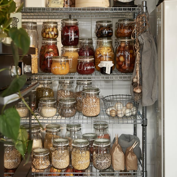 Shelves filled with glass KORKEN jars storing preserved foods, dried goods, and pickles, sealed with airtight lids.