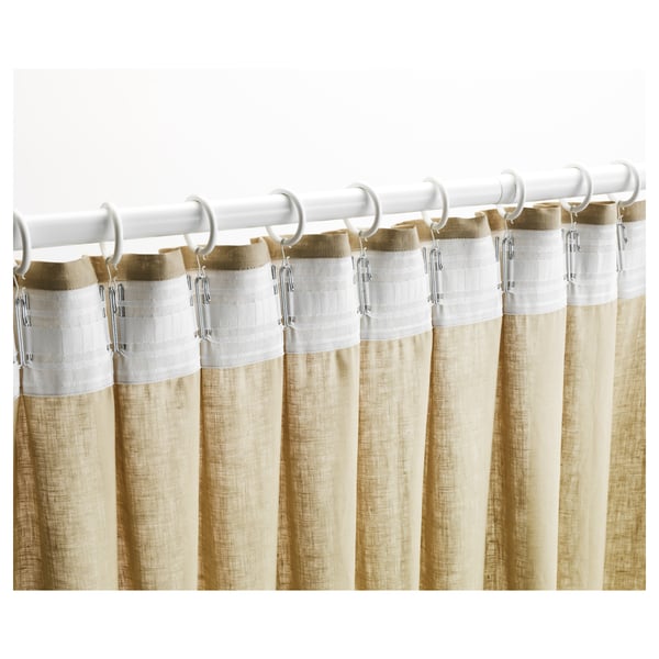 Beige curtains with white top section hang from white rod using hooks, displaying pleating tape for neat folds.