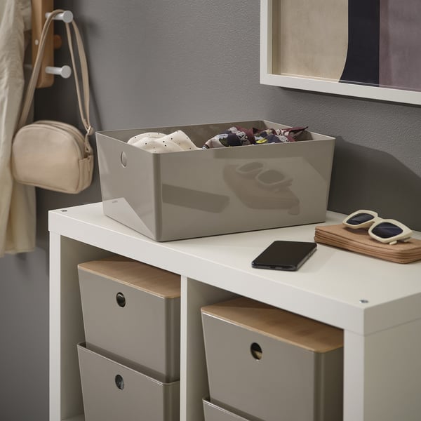 White storage box on desk, holding petty items, protecting contents from dust, stacking feature visible.