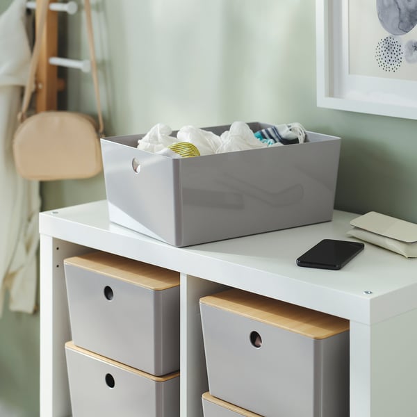 A set of KUGGIS storage boxes with lid on a shelf, ideal for organising items and stacking safely.