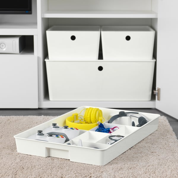 White organiser tray with gaming controllers and accessories, stored in compartments. Part of KUGGIS system for organising smaller items.