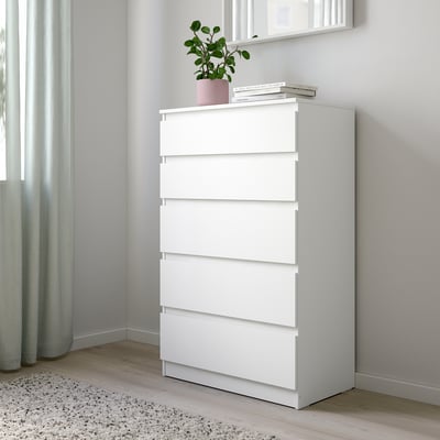 White KULLEN dresser in bedroom corner, with books and plant, tall, wide drawers.
