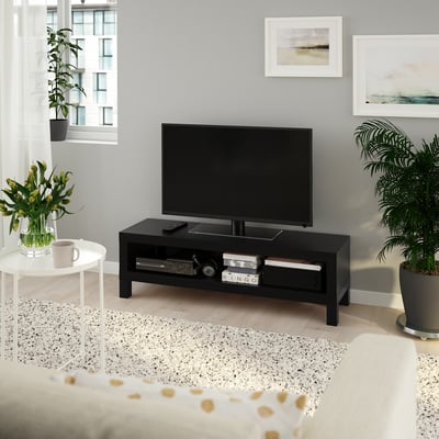 Modern LACK tv stand with flat screen, open storage, bed, coffee cup, plants, art prints, large window.