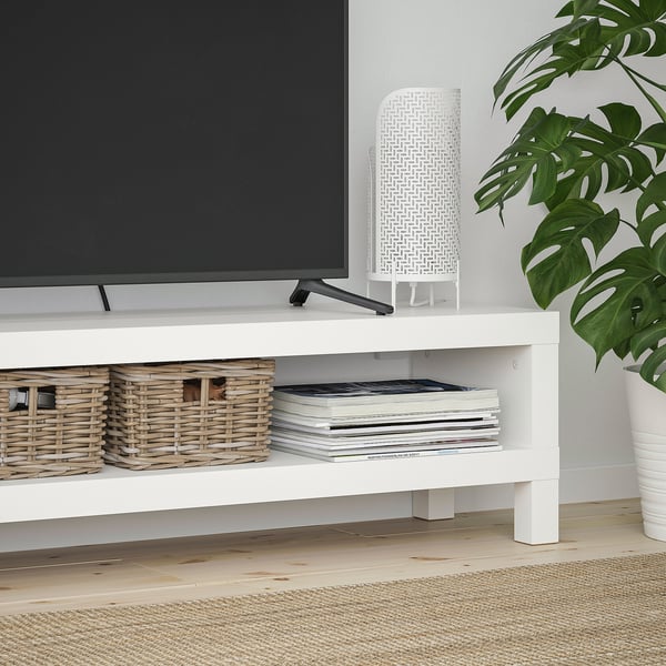 White tv stand with wicker baskets and books. Perfect for organising and storing media.