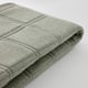 Folded grey fabric, soft texture, neat stitching, recycled material.
