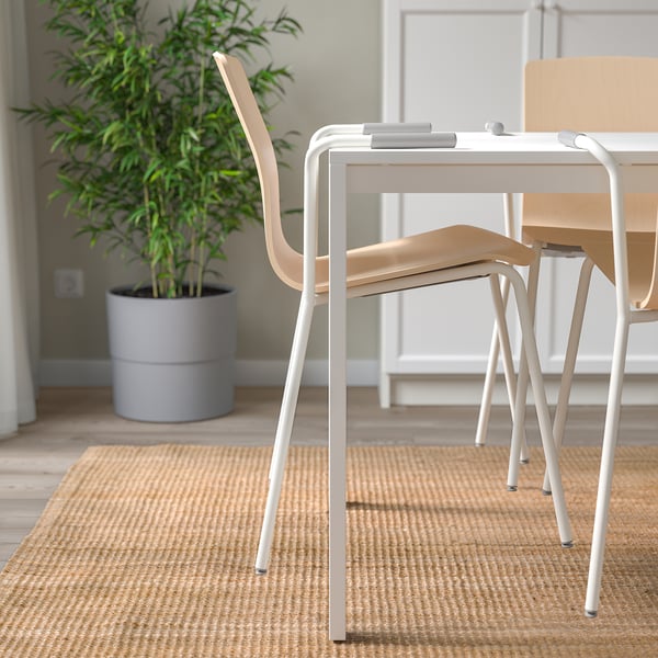 Modern office table setup with LÄKTARE chairs, featuring stackable, lightweight design, and lumbar support for posture comfort.