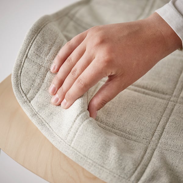 Image depicts a hand testing the comfort of a cushioned conference chair, showcasing its soft, supportive seat.