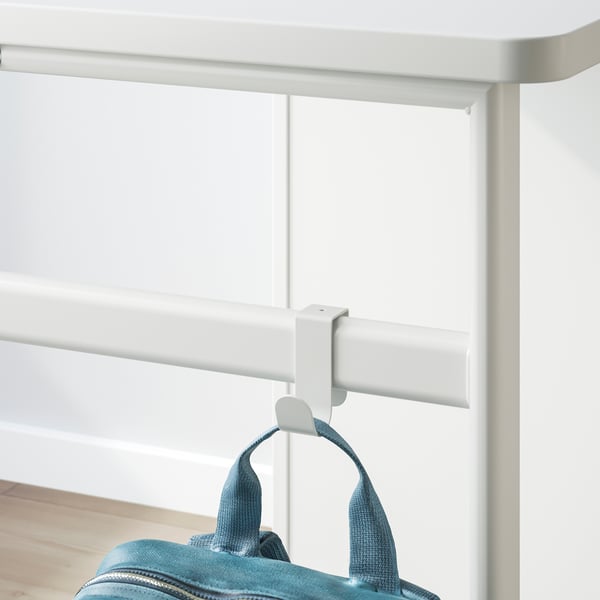 White desk with hooks, holding blue bag, showcasing practical storage and accessory attachment.