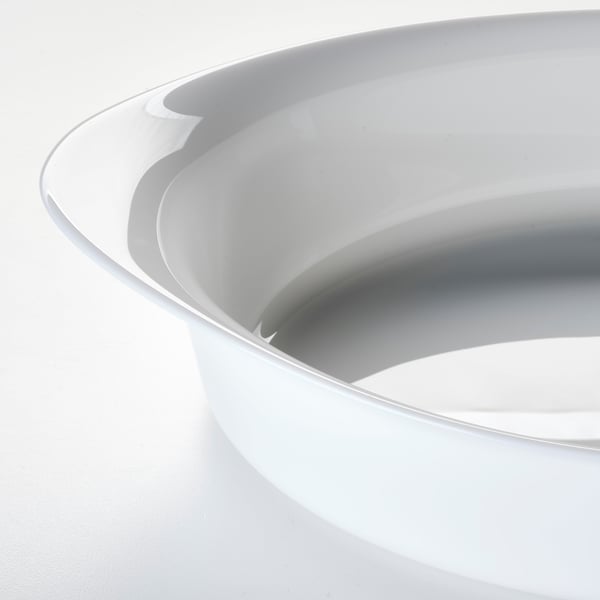 Stacked white glass dishes, smooth edges, gleaming surfaces.