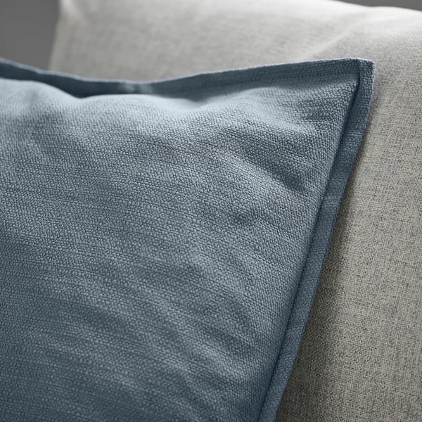 Close-up of a blue-grey cushion cover with textured, matte finish and zip detail.