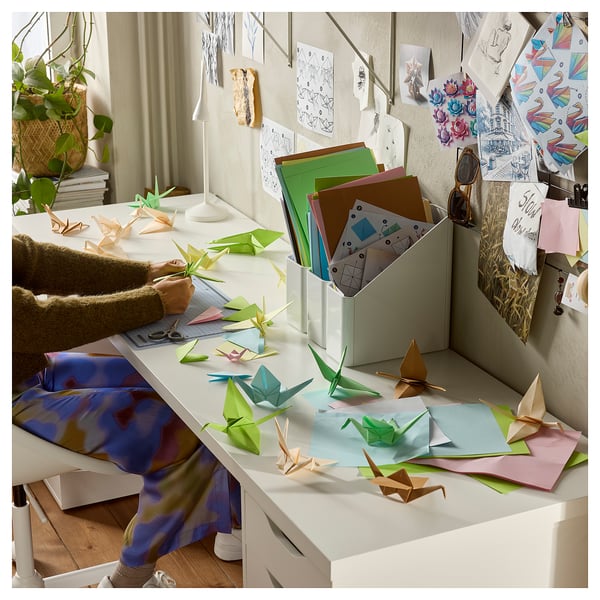 Creative workspace with LAGKAPTEN desk, origami, and crafting person.